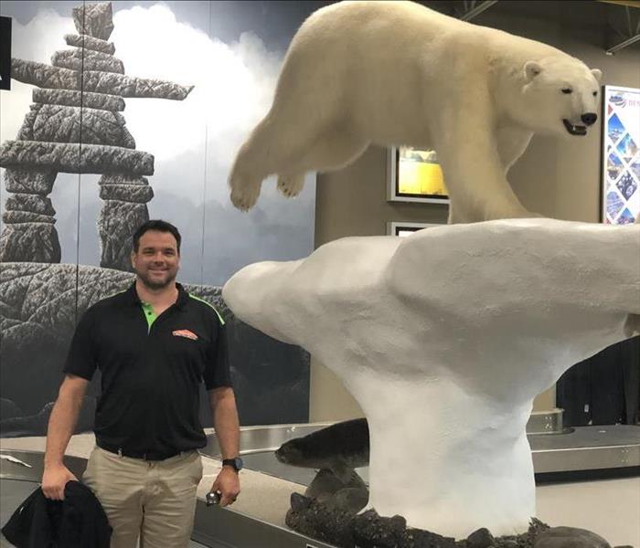 Owner standing beside Polar Bear statue at Yellowknife Airport