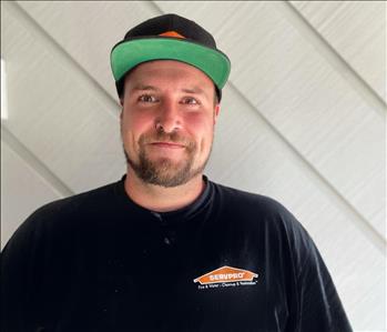 SERVPRO employee photographed in front of grey wall wearing a black t shirt. 