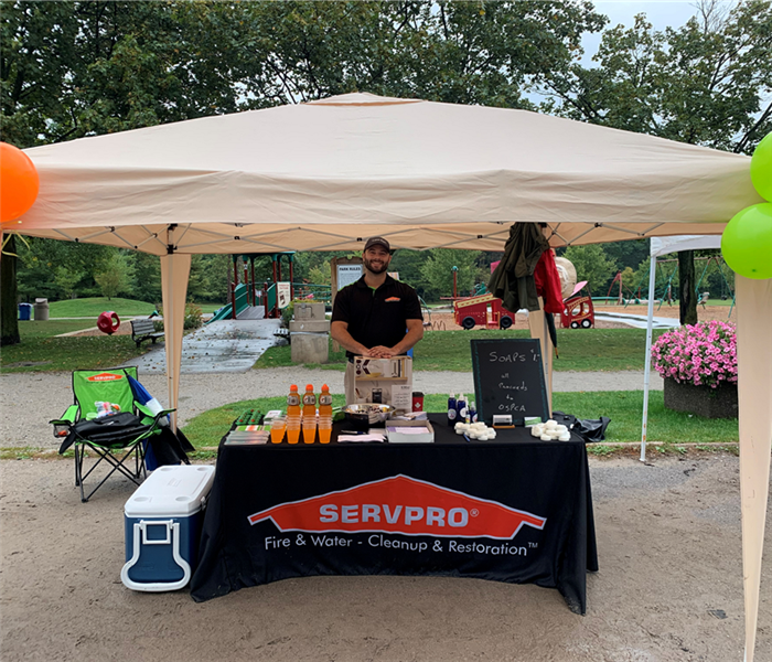 male employee standing behind our swag booth at the OSPCA Fundraising Walk